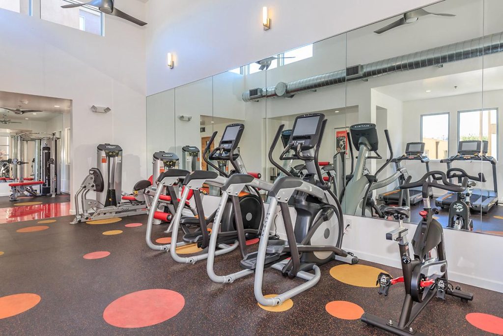 An apartment in Hollywood CA with a gym room equipped with exercise equipment and mirrors.