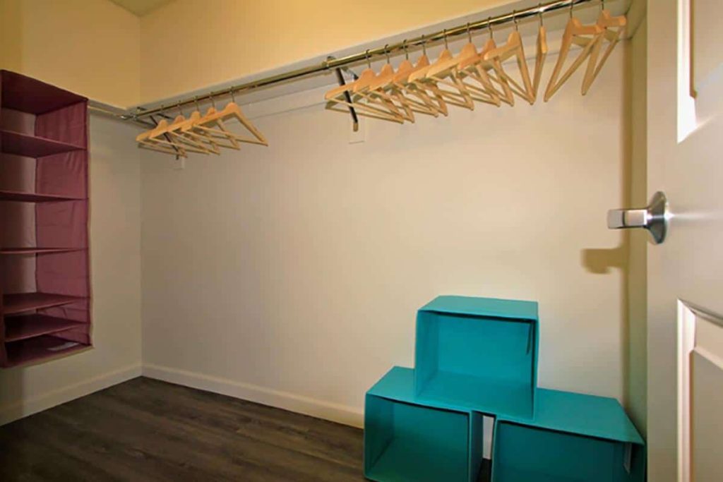 An immaculate closet in a Hollywood CA apartment, adorned with stylish clothes hanging on a rack.