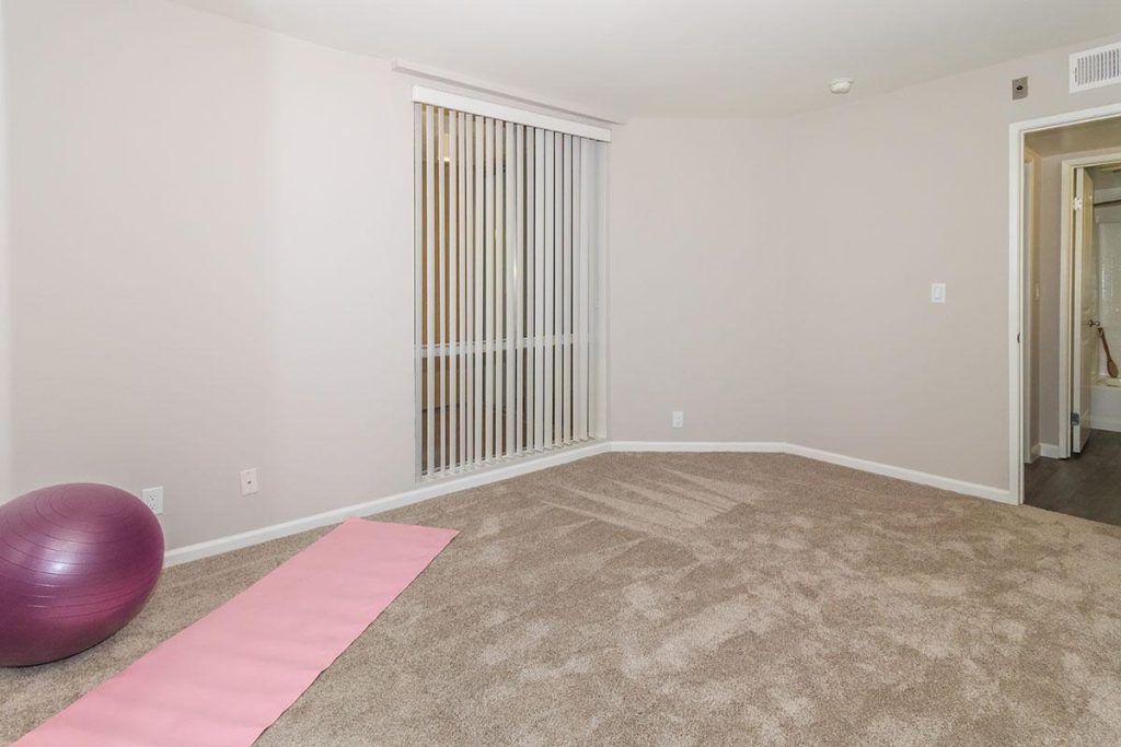 Apartment for rent in Hollywood CA: This apartment features a vibrant room complete with a pink yoga ball. Additionally, it offers the convenience of a sliding door, allowing for easy access to fresh air and