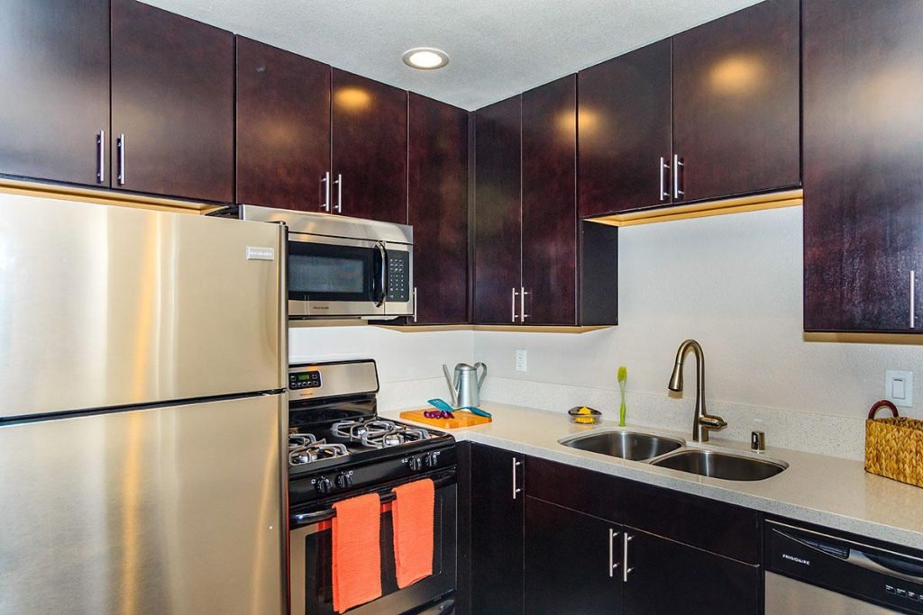 Spacious apartments in Hollywood CA featuring stainless steel appliances and stylish wooden cabinets.