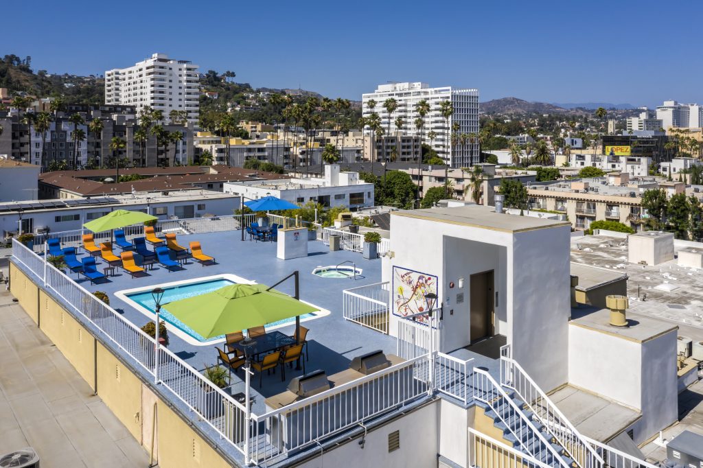 Discover luxurious apartments in Hollywood CA with a stunning rooftop pool, complete with comfortable lounge chairs and umbrellas for ultimate relaxation and enjoyment.