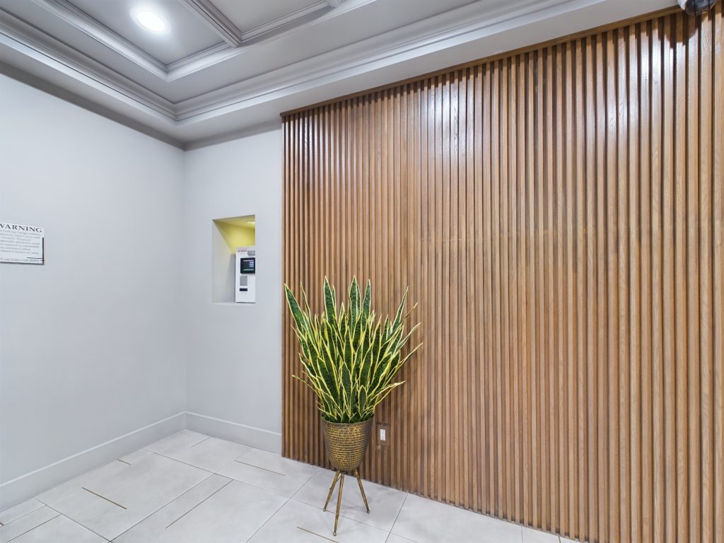 A charming hallway with elegant wood paneling and a vibrant plant in a decorative pot.