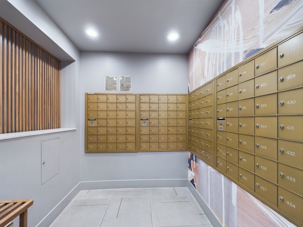 A hallway in Hollywood CA, featuring many mailboxes and a wooden bench.