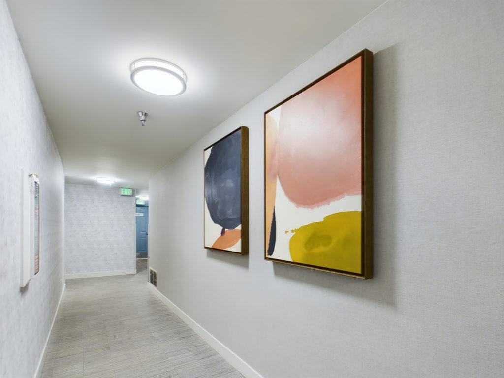 A hallway in Hollywood, CA with two paintings hanging on the wall.