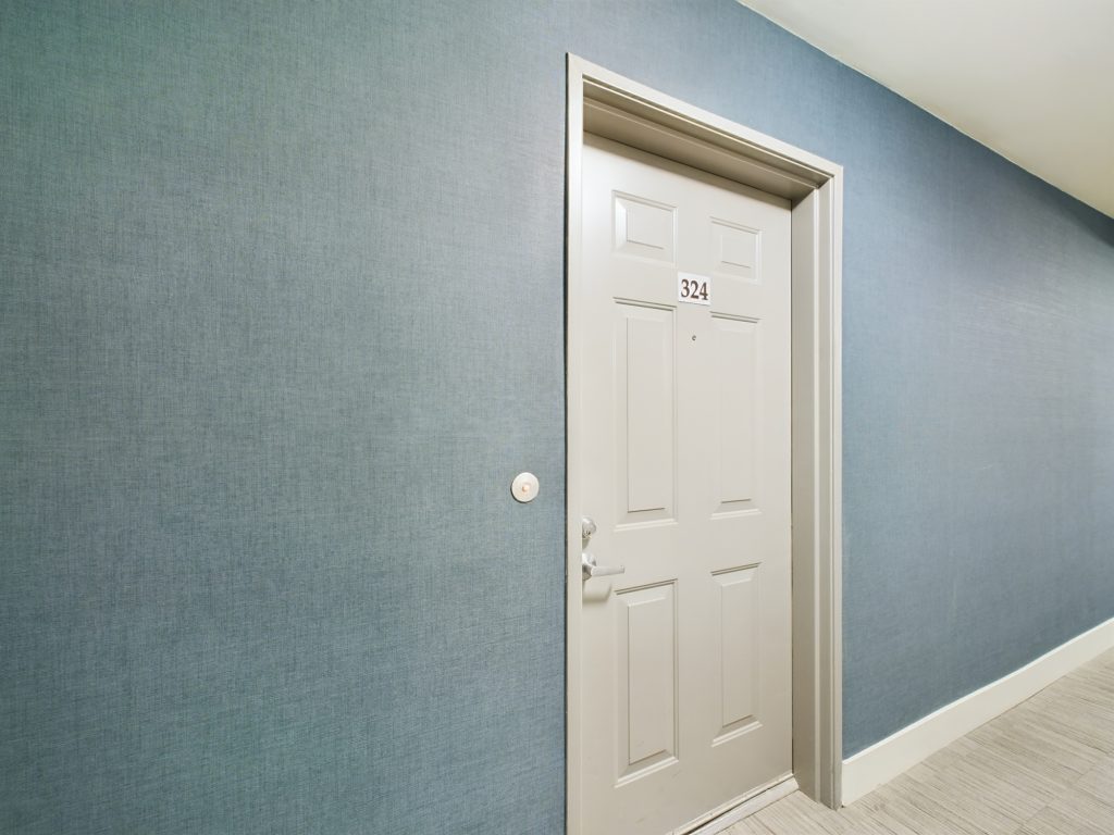 A hallway with blue walls and a white door in apartments for rent Hollywood CA.