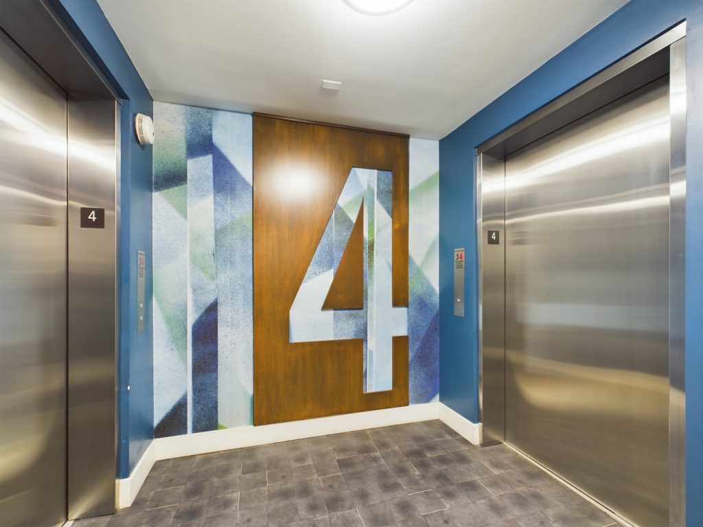 A Hollywood apartment elevator with the number four painted on it.