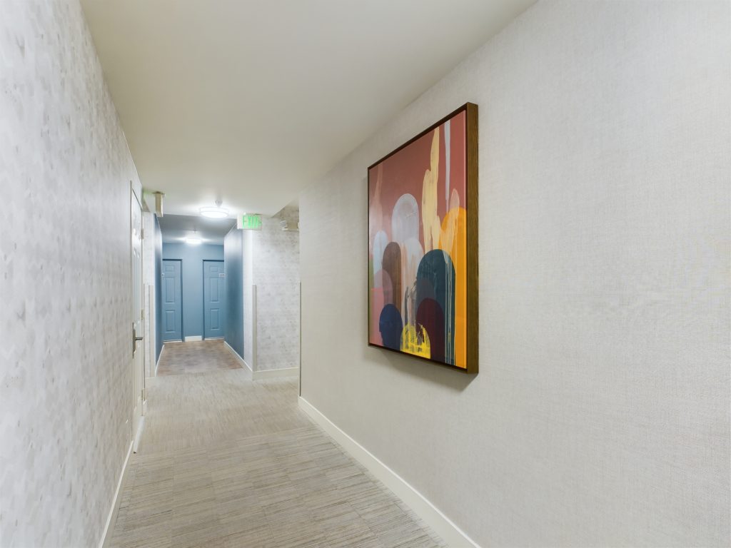 An elegant hallway in Hollywood CA featuring a captivating painting on the wall.