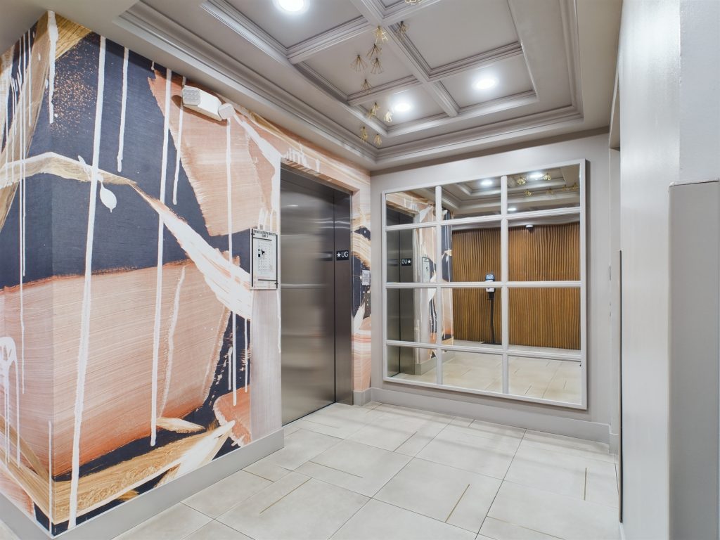 An elevator with a captivating mural on the wall, located in apartments for rent in Hollywood CA.