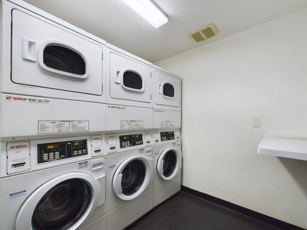 Apartments in Hollywood CA with a laundry room featuring several washers and dryers.