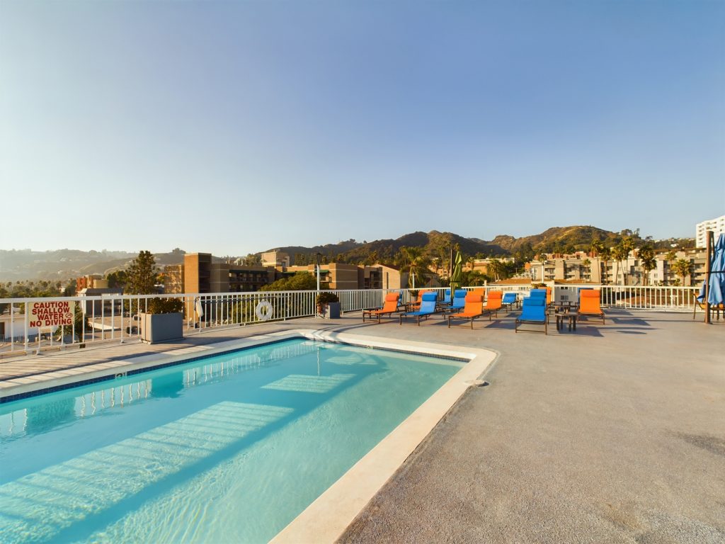 This Hollywood, CA rooftop pool offers a luxurious experience with comfortable lounge chairs and breathtaking mountain views in the background. Experience the ultimate in Hollywood apartment living with this stunning amenity.