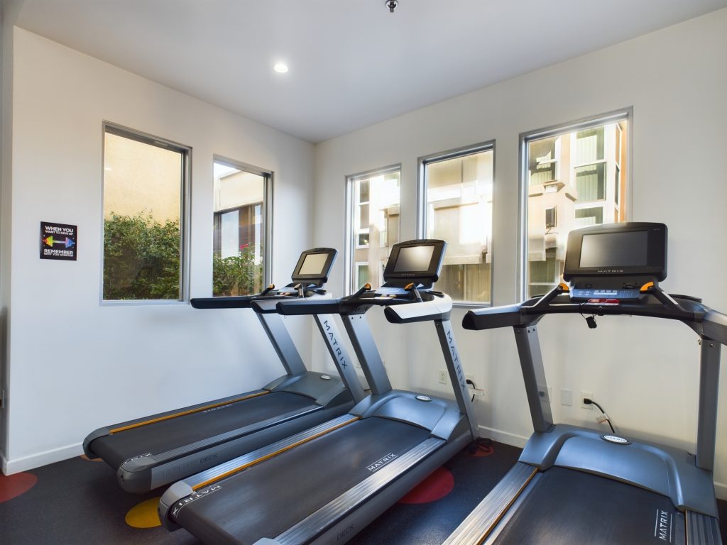 Two treadmill machines are available for use in a room with windows.